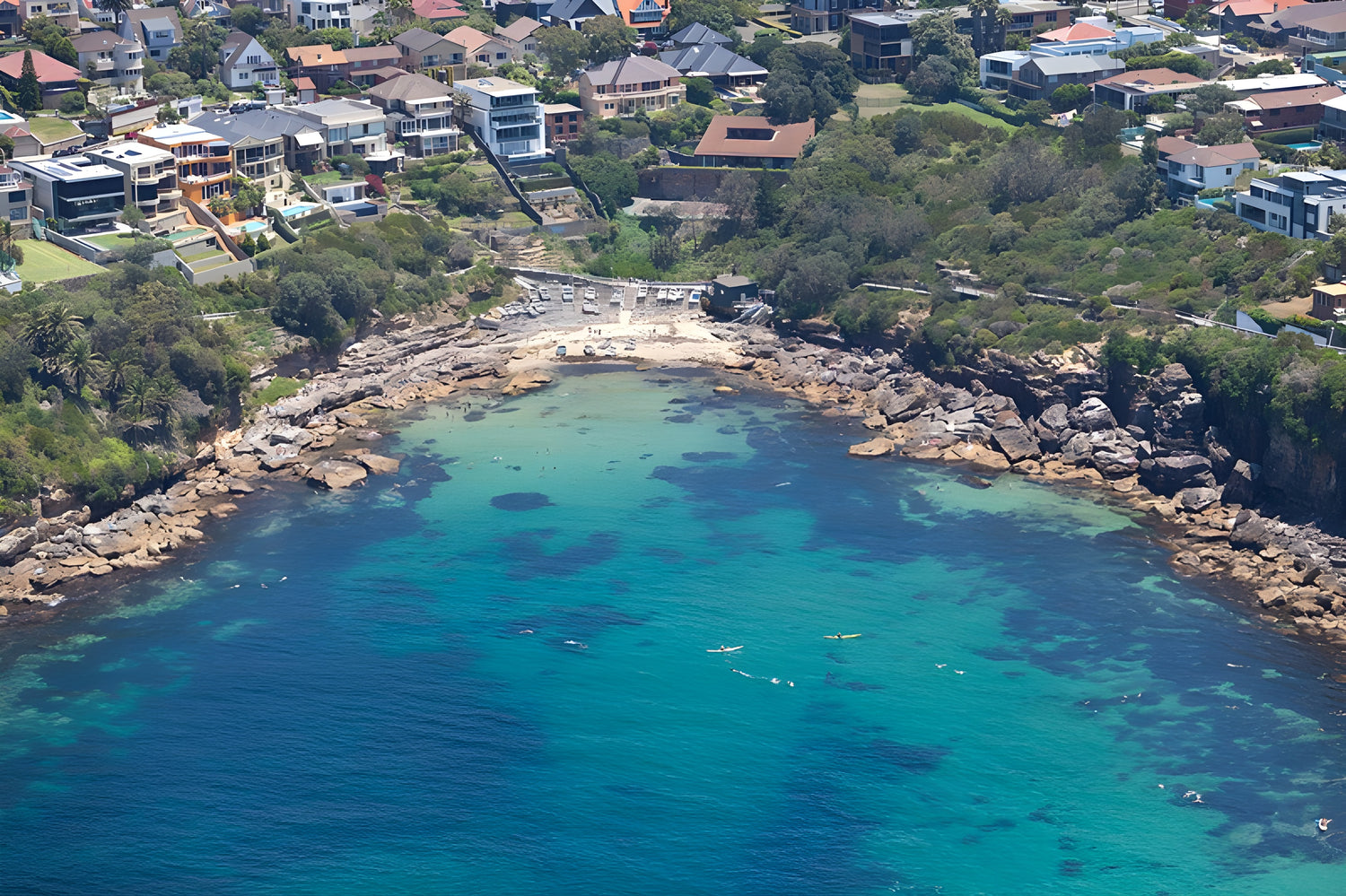 Aerial view of a coastal area with houses, rocks, and clear blue water.

infinity dive