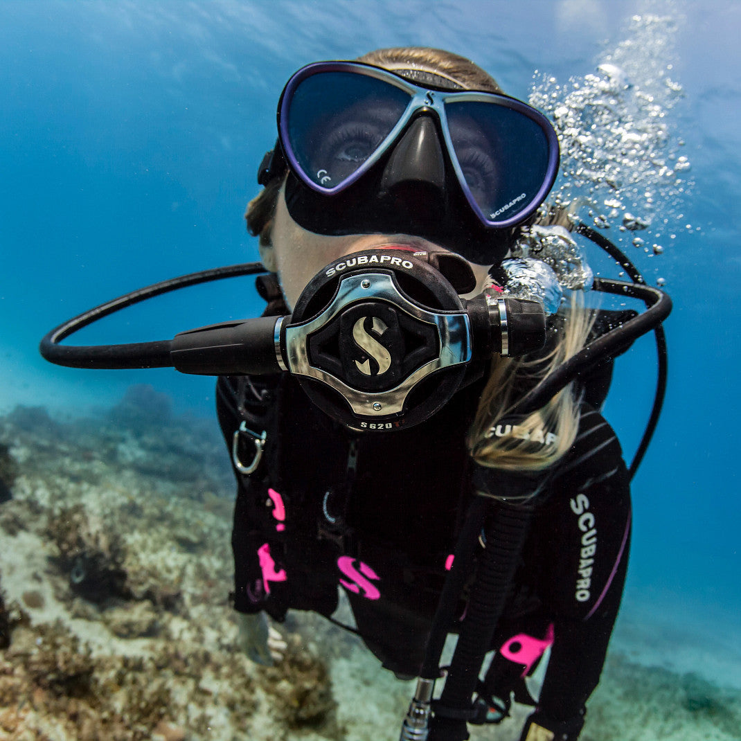 Real diving image showing the regulator system in active underwater use
