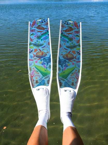 Colorful diving fins with a pattern held above water