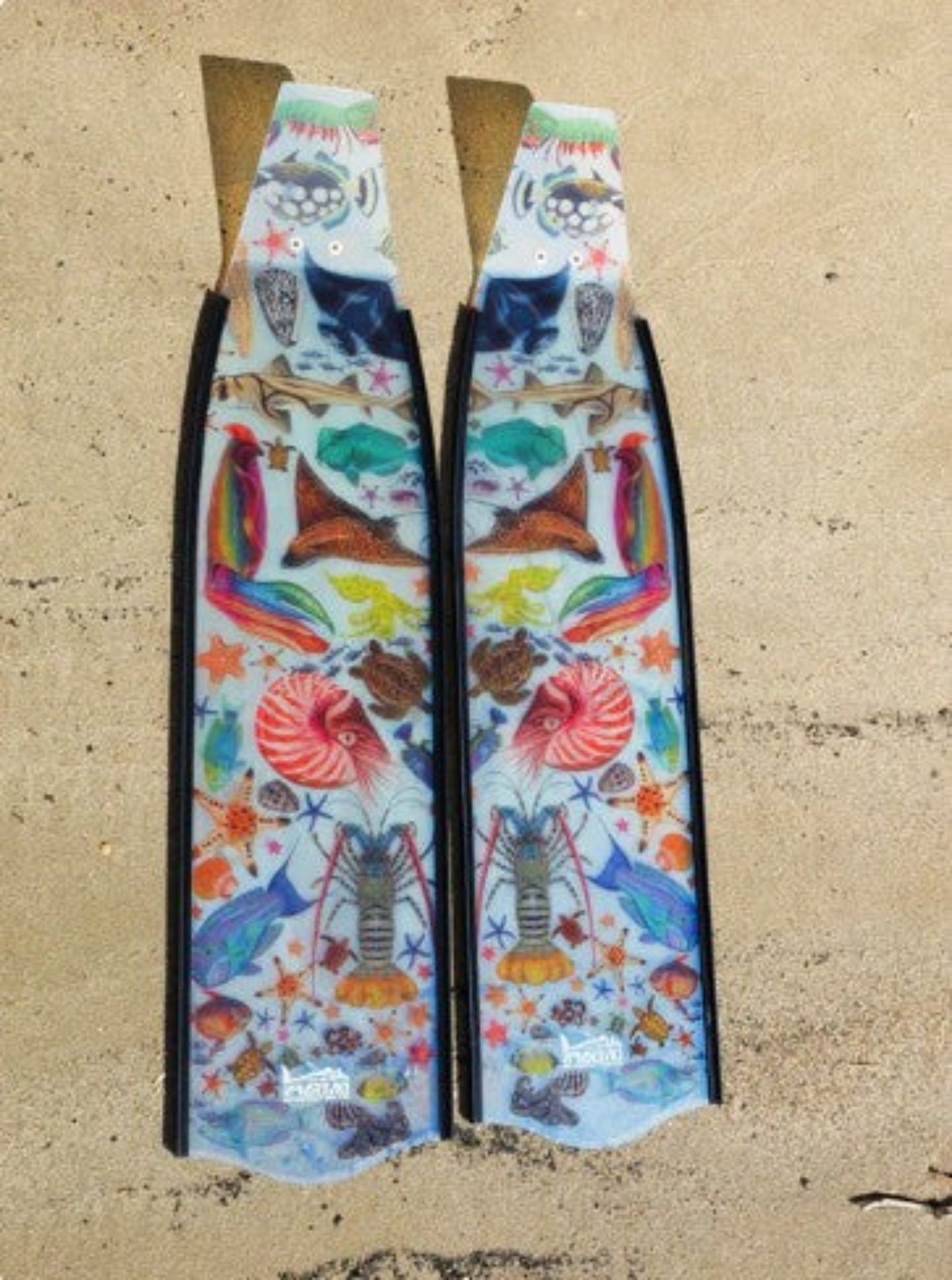Colorful fish-shaped fins with a pattern on a beige surface