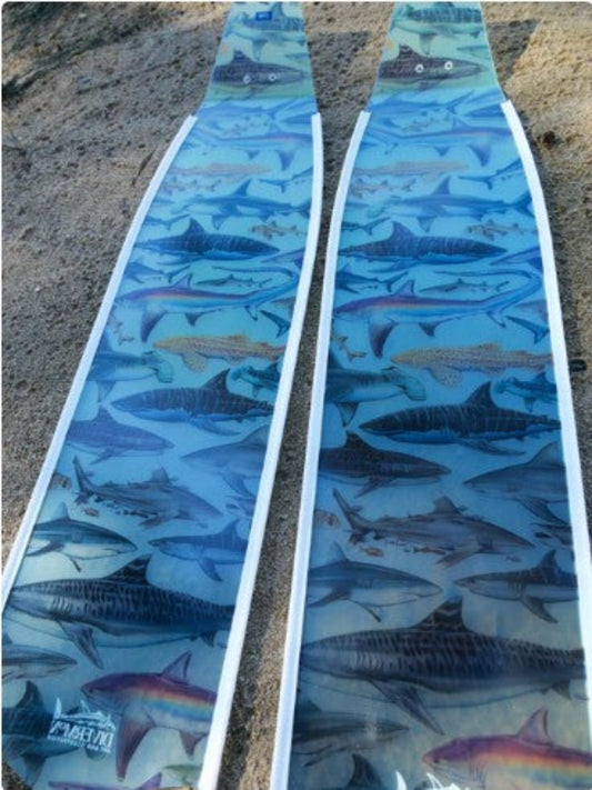 Pair of swim fins with shark pattern on a textured surface